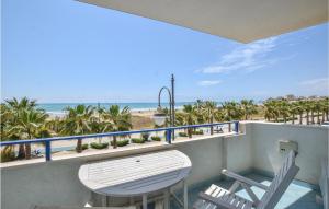 a balcony with a table and chairs and the beach at Gorgeous Apartment In Pozzallo in Pozzallo