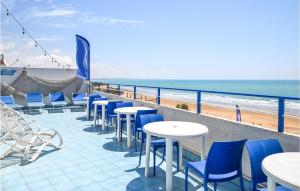 a patio with tables and chairs and the beach at Gorgeous Apartment In Pozzallo in Pozzallo
