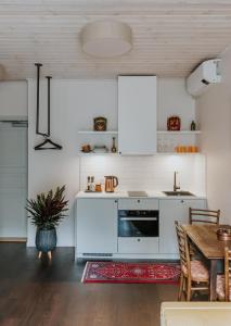 uma cozinha com armários brancos e uma mesa com um tapete em Old Hapsal Hotel em Haapsalu