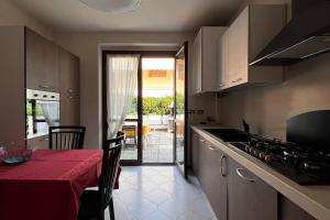 西爾米奧奈的住宿－Villa Grifone，厨房配有一张带红色桌布的桌子