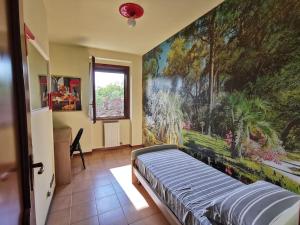 una camera da letto con un grande dipinto sul muro di Villa Grifone a Sirmione