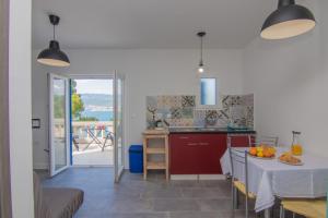 - une cuisine avec une table et une vue sur l'océan dans l'établissement Apartments Dunato Nedeljko, à Šilo
