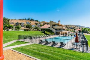 a swimming pool with chairs and a house at Lake Chelan Shores Sleek Stunner 19 to 4 in Chelan