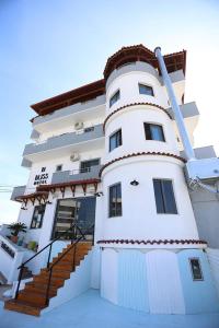 a white building with stairs on the side of it at BLISS Hotel in Ksamil