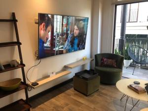 sala de estar con TV de pantalla plana grande en la pared en L1B 202 - Boutique apartamento en Cayalá para 4 huéspedes, en Guatemala