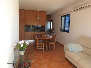 cocina y sala de estar con mesa y sofá en CAL GARRETA en L'Eucaliptus