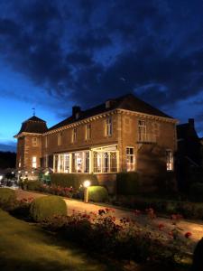 un gran edificio de ladrillo por la noche con luces en Hof de Draeck Bed & Breakfast en Teuven