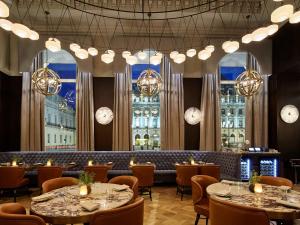 a restaurant with tables and chairs and large windows at Sofitel London St James in London