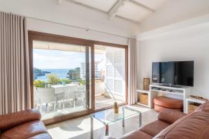 a living room with a couch and a television at Apartamento Estrella de Mar in Felanitx
