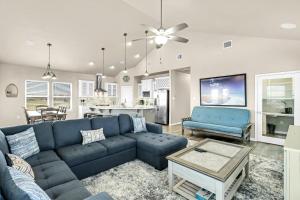 sala de estar con sofá azul y cocina en The Blue Pelican, en Corpus Christi