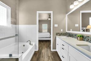 a bathroom with a tub and a sink and a mirror at The Blue Pelican in Corpus Christi +30 photos