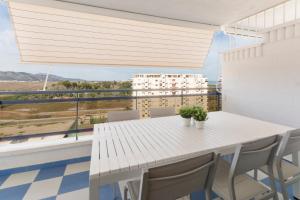 a white table and chairs in a room with a window at Ag Eden Resort in Gandía