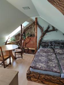 1 dormitorio con cama, mesa y pared de ladrillo en U Vodníka, en Mohelnice