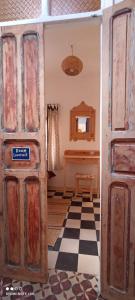una vecchia porta in una stanza con pavimento a scacchi di Vallparadis Pension Familiar" FIRDAUS" a Chefchaouen