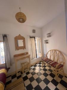 Zimmer mit einem karierten Boden, 2 Stühlen und einem Spiegel in der Unterkunft Vallparadis Pension Familiar" FIRDAUS" in Chefchaouen