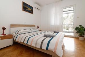 ein Schlafzimmer mit einem großen Bett und einer gestreiften Decke in der Unterkunft Apartments Jasna 3 in Novigrad Istria