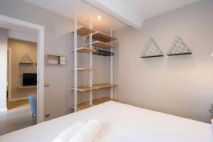 a bedroom with a white bed and shelves at Fabulous 3 bedrom Attic in Sant Andreu with terrace wifi in Barcelona