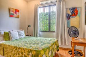 a bedroom with a bed and a window at Casa Iorio in Jacó +26 photos