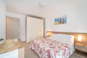 1 dormitorio con cama, mesita de noche y cama sidx sidx sidx sidx sidx en Residenza Monica, en Lignano Sabbiadoro