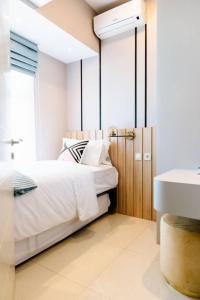 Habitación blanca con cama y lavabo en kimaya at Benson Pakuwon Mall, en Surabaya