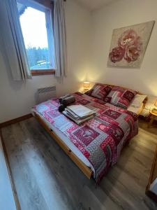 a bedroom with a bed with a red blanket and a window at Chalet de Montalbert 22B in Montalbert