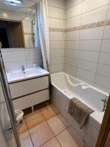 een badkamer met een bad, een wastafel en een bad bij Chalet de Montalbert 22B in Montalbert