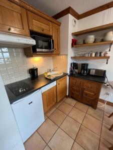 een keuken met houten kasten en een witte koelkast bij Chalet de Montalbert 22B in Montalbert