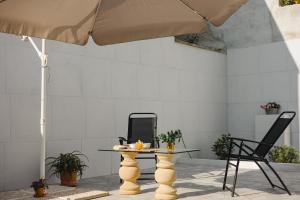 a table and a chair and an umbrella at Casa Alerà con idromassaggio in Lecce
