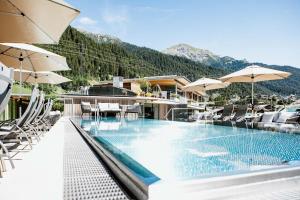hotel z basenem z leżakami i parasolami w obiekcie Hotel Arlmont 4 Stern Superior w mieście Sankt Anton am Arlberg