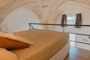 łóżko w pokoju z ceglaną ścianą w obiekcie Casa Alerà con idromassaggio w mieście Lecce