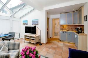 un salon avec un canapé et une cuisine dans l'établissement Ferienwohnung Bootsmann, à Westerland 9 autres photos