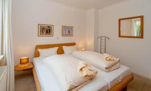 une chambre avec deux lits avec des draps blancs dans l'établissement Ferienwohnung Bootsmann, à Westerland
