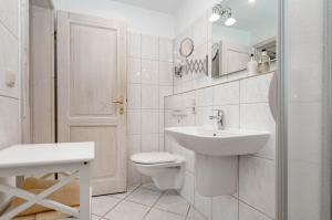 une salle de bains blanche avec toilettes et lavabo dans l'établissement Ferienwohnung Bootsmann, à Westerland