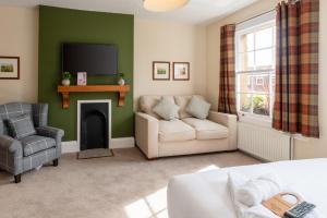 a living room with a couch and a fireplace at The Richard Onslow in Cranleigh