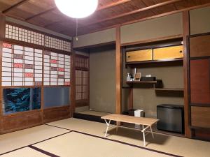 una habitación con una mesa y un banco en ella en Guesthouse Yululu, en Kioto
