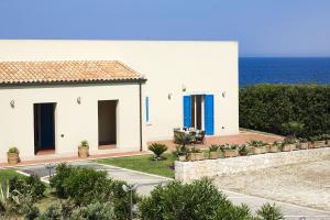 una casa bianca con l'oceano sullo sfondo di Villa Ala ad Augusta