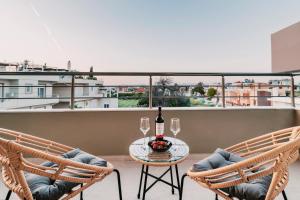 a table with two chairs and a bottle of wine on a balcony at Seascape House in Kremasti