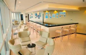 una sala d'attesa con sedie bianche e un bar di Orion City Hotel a Colombo