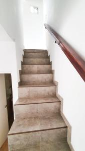 a staircase in a house with a wooden rail at Acacias in Mar de Ajó