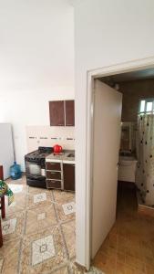 uma cozinha com uma porta aberta para uma cozinha com um fogão em Acacias em Mar de Ajó