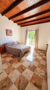 a bedroom with a bed and a checkered floor at Acacias in Mar de Ajó