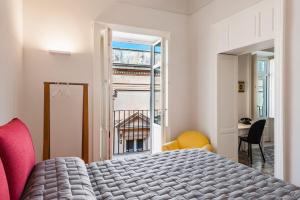 una camera da letto con un letto e una finestra di 2 Soru Ortigia Holiday Home - Attico con terrazza a Siracusa