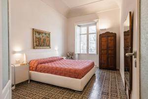 una camera da letto con un letto e una finestra di 2 Soru Ortigia Holiday Home - Attico con terrazza a Siracusa