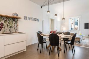 una cucina e una sala da pranzo con tavolo e sedie di 2 Soru Ortigia Holiday Home - Attico con terrazza a Siracusa