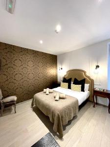 a bedroom with a large bed and a chair at Hostal El Caprichito Marbella in Marbella