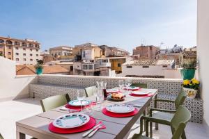 un tavolo sul balcone con vista sulla città di 2 Soru Ortigia Holiday Home - Attico con terrazza a Siracusa