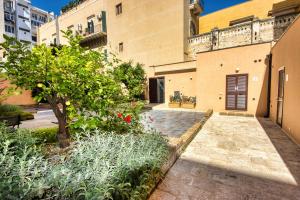 un cortile di un edificio con un albero e piante di Giardino dei Lenti - Self check-in Apartments a Bari