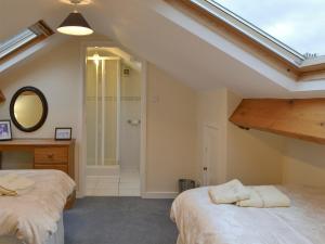a attic bedroom with two beds and a shower at Quiet Ways in Portinscale