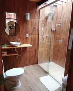 a bathroom with a shower with a toilet and a sink at Chalé Mirante da Pedra in Serra de São Bento