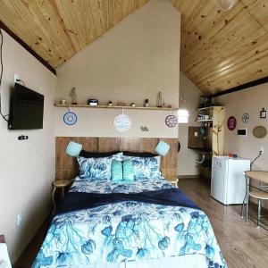 1 dormitorio con 1 cama con edredón azul en Chalé Mirante da Pedra, en Serra de São Bento